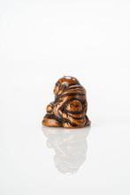 Een boxwood netsuke van Hotei met een glimlach op zijn