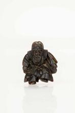 Een bijzondere geperste hoorn netsuke met de afbeelding van