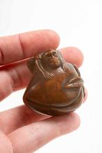 Een netsuke van Buxus die een aap op een perzik afbeeldt -