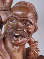 Standing deity or immortal carrying a bag and tool - Hout -