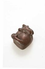 Een houten netsuke van een muis met zijn staart gedraaid die