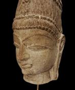 in de middeleeuwen - Hoofd van een godheid in roze zandsteen