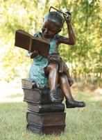 Bronzen lezend meisje met bril - 54x51x94cm - 25Kg, Nieuw, Mensenbeeld, Metaal, Verzenden