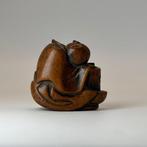 Een houten netsuke van een slapende ambachtsman, Edo-periode
