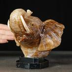 Met de hand gesneden olifantenhoofd van onyx op een zwarte