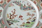 Onderbord - Een Chinees Famille Rose bord versierd met een