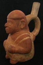 Moche-figuur van een zittende man met een coca-bladeren tas