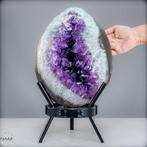 Majestueus amethisten kristallen ei op een edel voetstuk Van