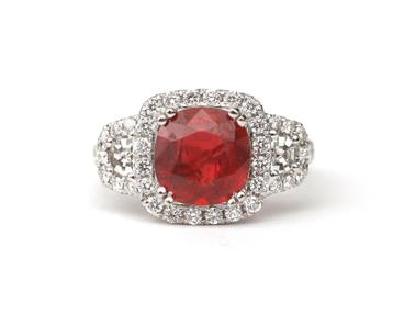 Een 18 krt. witgouden entourage ring met robijn en diamant beschikbaar voor biedingen