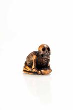 Een Japanse netsuke van buxushout die een skelet met een kom