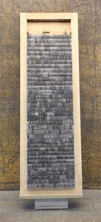 een letterbak gevuld met 2 alfabetten loden drukletters uit