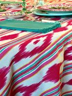 Mantel met ikat-strepen in fuchsiatint voor grote tafels.