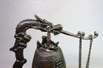 Brons - bel, draak-draai klok. Kloklichaam versierd met