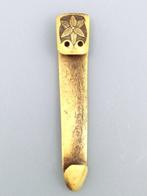 Obihasami Netsuke met een bloemmotief aan de voorkant en