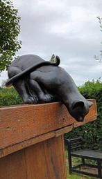 sculptuur, Sculptuur van een zwarte kat wie over de rand