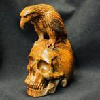 Sculptuur van een raaf op een menselijke schedel, met de