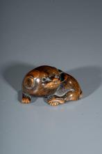 Een fijn gesneden boxwood netsuke die een hurkende hond
