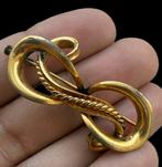 Een curieuze en verfijnde broche van verguld metaal met een