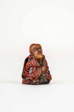 Een polychrome houten laknetsu die een monnik met waaier