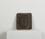 Een keramieken vaas en metalen hoofd